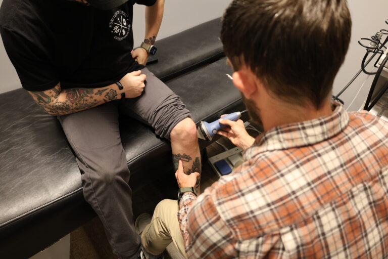 Dr. Bryan performing shockwave therapy on a patient's lower leg in Johnson City, TN
